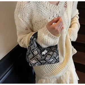 Detail of hobo shoulder bag with black and white floral pattern on a female model