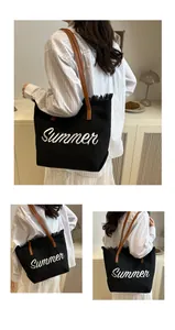 Detalle de bolso tote de lona negra con bordado Summer blanco y flecos en los bordes