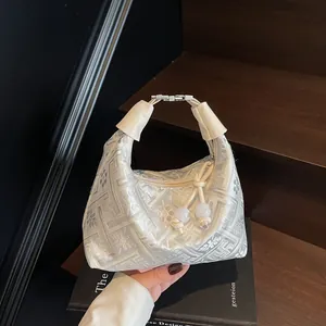 Elegant silver brocade dumpling bag with leather handle and traditional floral pattern