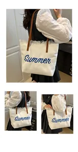 Primer plano de bolso tote de lona blanca con bordado Summer azul y asas de cuero marrón