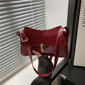 Chic dark red glossy patent leather underarm saddle bag with gold oval buckle hardware