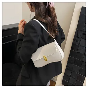 Detail of white minimalist shoulder bag with gold metal twist lock and sleek finish