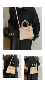 Detail view of apricot leather handbag showing gold twist lock and adjustable strap