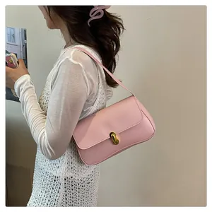 Detail shot of light pink underarm bag with gold hook clasp on soft leather shoulder strap