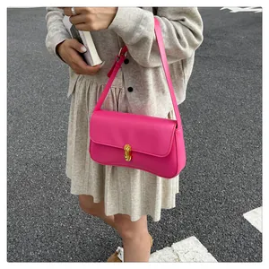 Detail of hot pink shoulder bag with gold metal twist lock and matte leather texture