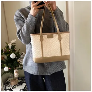 Détail de la texture tressée et fermeture éclair sur le grand sac cabas blanc crème