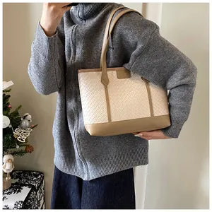 Détail du sac cabas tissé beige et marron avec ses fines bandoulières de qualité