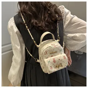 Detail of mini floral bunny backpack featuring golden logo and twist lock on creamy white leather