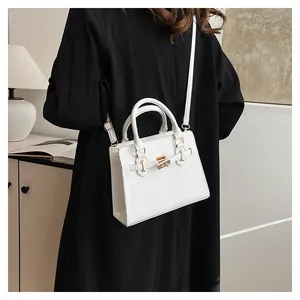 Detailed side view of white leather crossbody bag with golden buckle on a fashion model