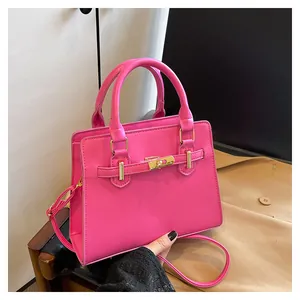 Detail of rose pink leather handbag with gold twist lock and adjustable shoulder strap