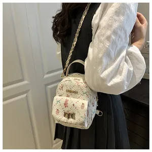 Detalle de mini mochila floral con cadena dorada y cierre metálico de estilo dulce