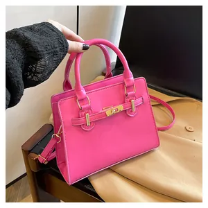 Detailed view of magenta tote bag with gold twist lock and adjustable shoulder strap