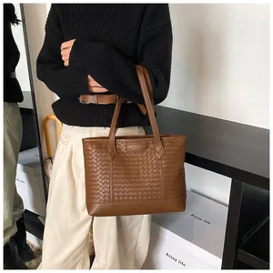 Vue détaillée de la texture tressée marron et de l'étiquette sur le sac fourre-tout