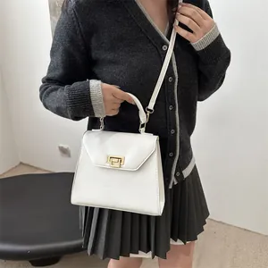 Borsa a mano bianca lucida con fibbia dorata e tracolla rimovibile indossata dal modello