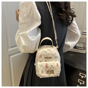 Detalle de la mini mochila blanca con estampados de animales y logo dorado de moda