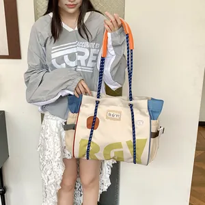 Detailed view of the large canvas tote bag with contrast blue side pocket and rope handle