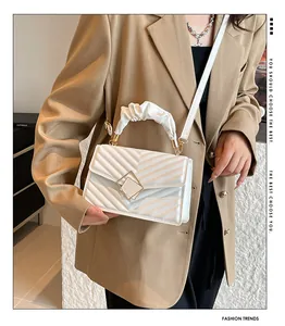 Witte gewatteerde crossbodytas met ruches handvat gedragen op een kaki blazer
