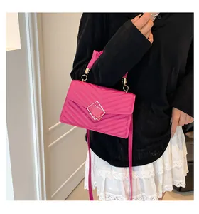 Model draagt een magenta handtas met V-vormige stiksels en gouden draaisluiting
