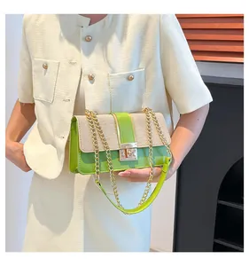 Détail du sac patchwork en cuir vert et tissu tissé beige avec chaîne dorée