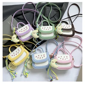 Detailed view of colorful cherry embroidered mini handbags with plush moon charms