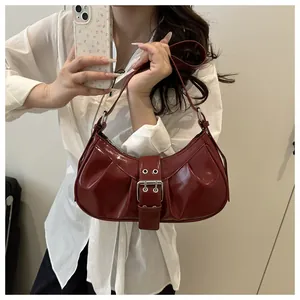 Détail du sac croissant en cuir verni bordeaux avec grande boucle en métal argenté