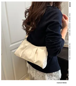 Close-up of creamy white pleated leather cloud bag with soft texture and gold hardware