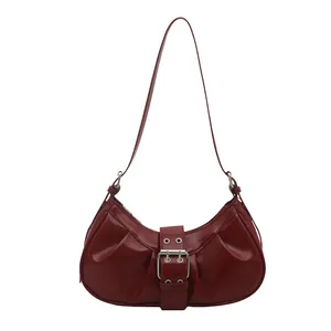 Sac lune minimaliste bordeaux en cuir verni avec plis et boucle argentée chic