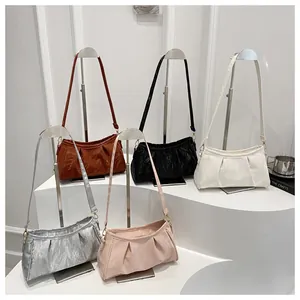 Detail showing various colors of cloud bags with pleated leather texture on white steps