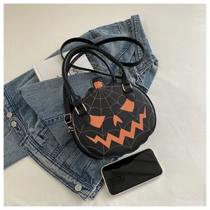Detail of Halloween pumpkin bag with orange face and gold spider web stitching