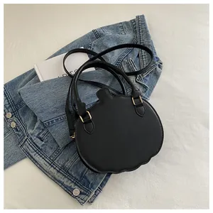 Detailed view of the black pumpkin-shaped fashion handbag with fine gold metal rings