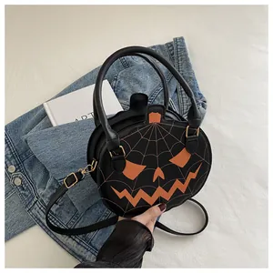 Detail showing pumpkin face embroidery and web pattern on black leather crossbody bag