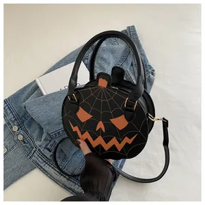 Detail of black pumpkin-shaped handbag with orange spider web embroidery and pumpkin face