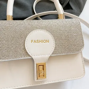 Detail of the white faux leather shoulder bag featuring silver sequins and gold buckle