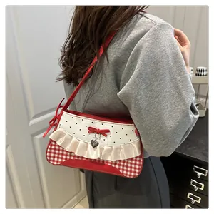 Close-up of red and white checkered bag with lace trim and heart pendant detail