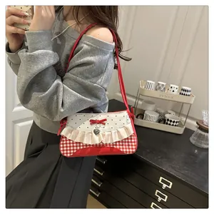 Detail of red and white checkered bag with lace trim, bow and silver heart charm