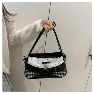Detail of lace bow, heart pendant, and checkered fabric on a sweet aesthetic shoulder bag