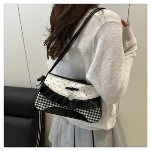 Side view of cute polka dot shoulder bag with lace trim and heart charm on a model