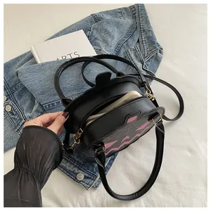 Detail of bat-shaped crossbody bag showing phone storage capacity and spiderweb stitching