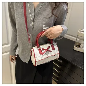 Detailed shot of bow-knot Boston bag with red polka dots and lace edges on a model