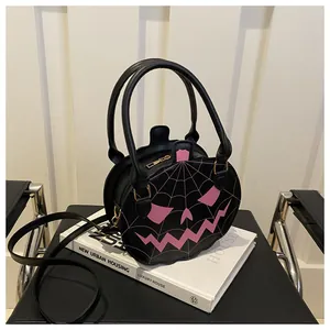 Detail of pumpkin shaped crossbody bag featuring pink spiderweb embroidery and black PU leather