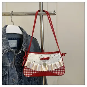 Detailed view of red and white gingham shoulder bag with lace trim and heart charm