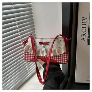 Detail of red gingham shoulder bag with lace trim and heart pendant charm