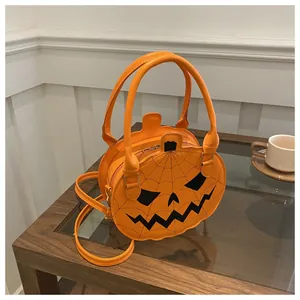 Detail view of pumpkin handbag with spider web stitching and black jack-o'-lantern face