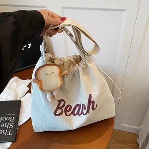 Off-white canvas drawstring tote bag with Beach print and cute toast plush charm