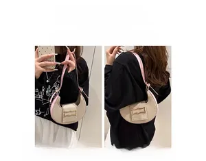 Detalle de bolso media luna de lona beige y cuero rosa en estilo de mano y de hombro