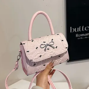 Sac à main rose plissé avec imprimé nœuds et fermoir cœur en vue lifestyle sophistiquée
