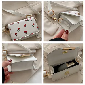 Detail van de mini witte kersentas met compact interieur voor lippenstift en magneetsluiting
