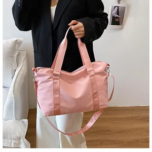 Dettaglio borsa da viaggio rosa con tracolla regolabile e tessuto nylon robusto