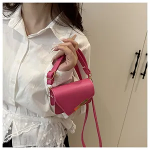 Détail du sac bandoulière rose fuchsia avec bordure dorée et lanière en similicuir