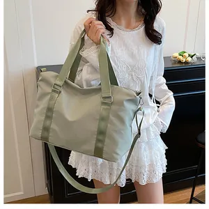 Dettaglio della borsa sportiva in nylon verde chiaro con tracolla e manici in tessuto